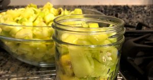 Ball mason jar packed with cut banana pepper pieces for waterbath canning