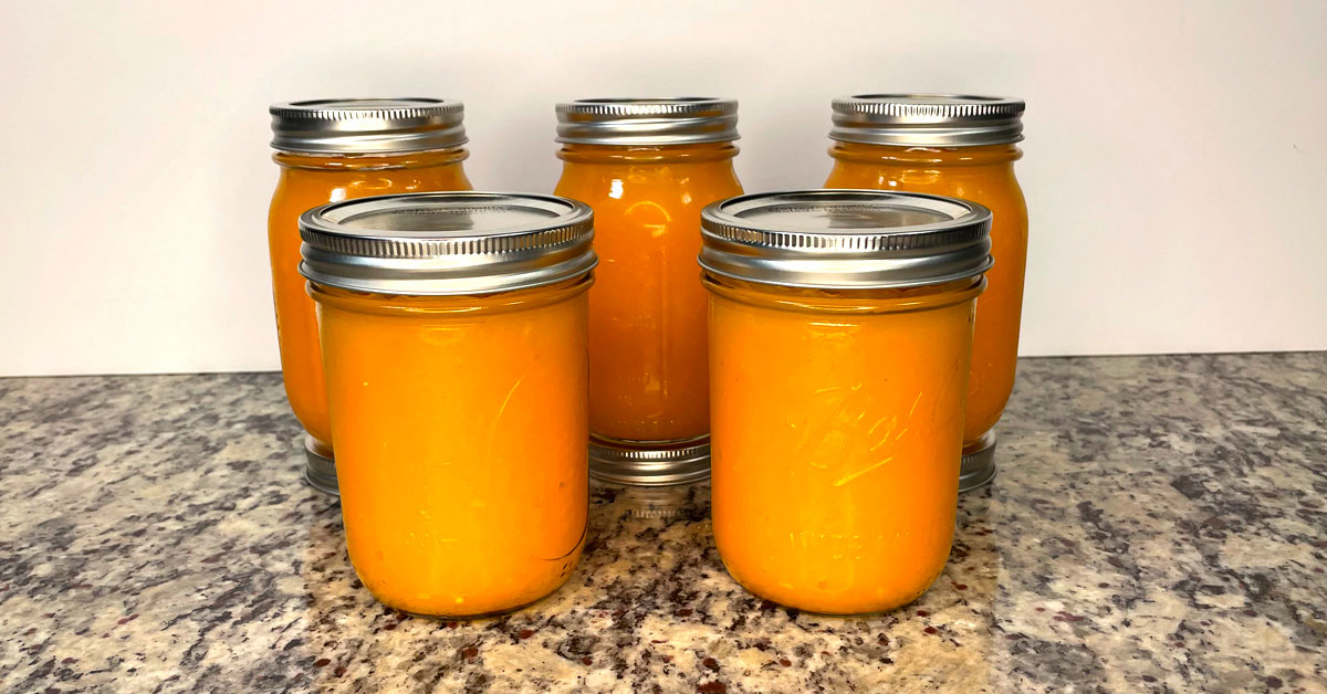 Five Ball mason jars with pumpkin puree ready to be frozen
