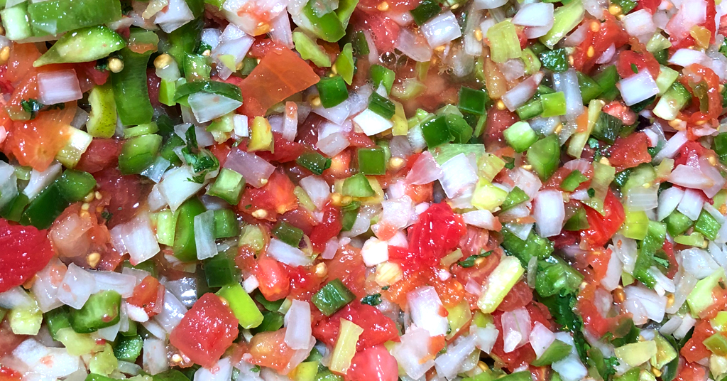 Tomatoes, peppers, onions combined in a bowl for Zesty Salsa recipe