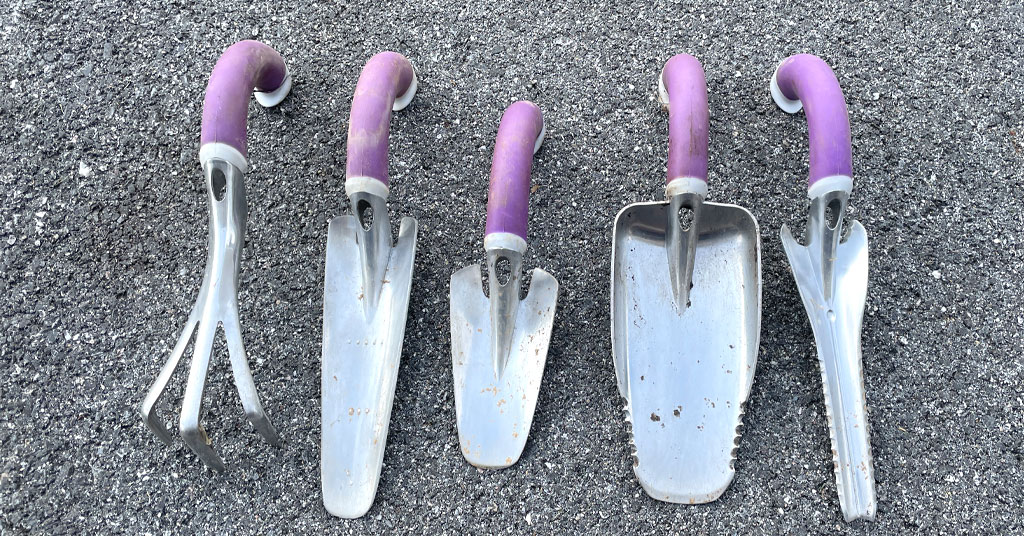 Set of five ergonomic garden tools with purple handles.