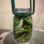Pint Jar of Green Beans being lowered into a pressure canner for canning.