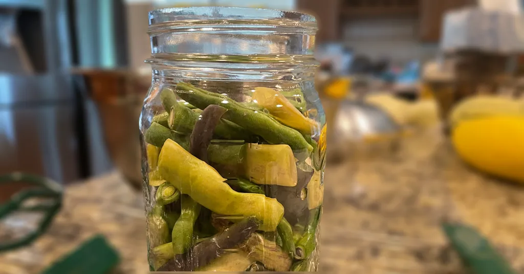 Various types of Green Beans packed in a hot mason jar with 1 inch of headspace.